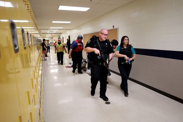 The Cherokee County Sheriff's Office conducts an active shooter drill as part of training last year at Mill Creek Middle School in Woodstock. A bill that would require all of the state's public schools to conduct such drills gained final approval in the General Assembly this past week. It's now headed to the desk of Gov. Brian Kemp for his signature. Kemp asked for the bill. (Jason Getz/The Atlanta Journal-Constitution/TNS)