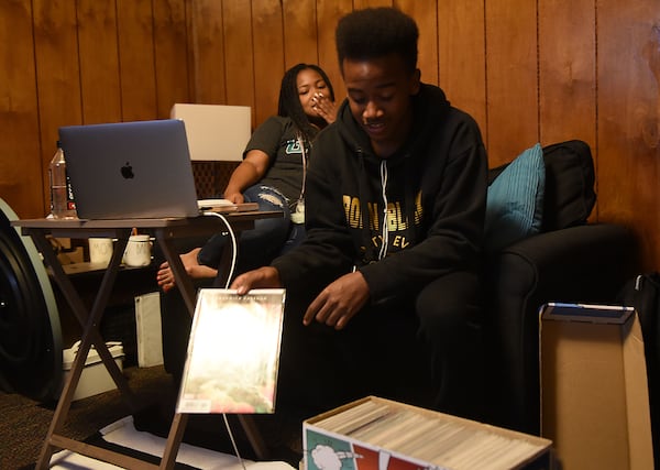 Tatiana Edwards watches her 15-year-old son Malachi with pride as he shows off his impressive comic book collection. Edwards, a student at Georgia Northwestern Technical College, had to get accustomed to pursuing her degree during quarantine. Edwards is a student at the college juggling work, raising two sons, Josiah (left), 6, and Malachi, 15. Edwards is also the student government leader on campus. (Ryon Horne/RHORNE@AJC.COM)