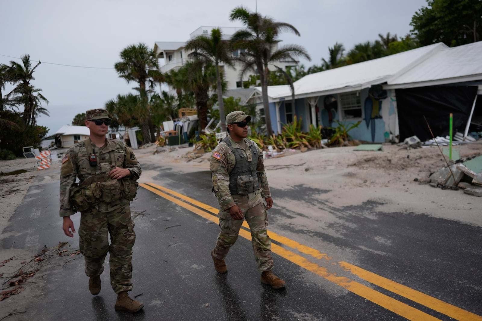 Members of the Florida Army National Guard walk past a home slated for demolition after being damaged in Hurricane Helene, as they check for any remaining residents, ahead of the arrival of Hurricane Milton on Tuesday.