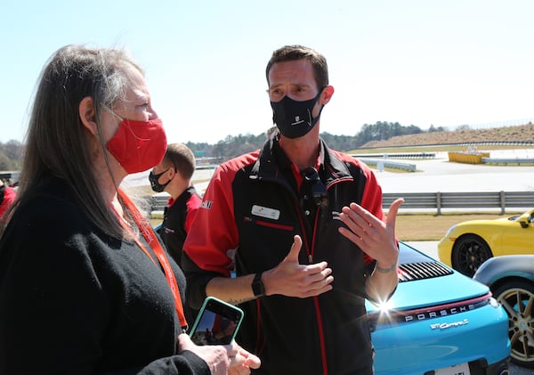 Atlanta, GA - 03-08-21 Porsche instructor Chris Ivester (R) speaks to reporter Mary Welch at the Porsche Experience Center Atlanta on International Women's Day. (Tyson Horne / tyson.horne@ajc.com)