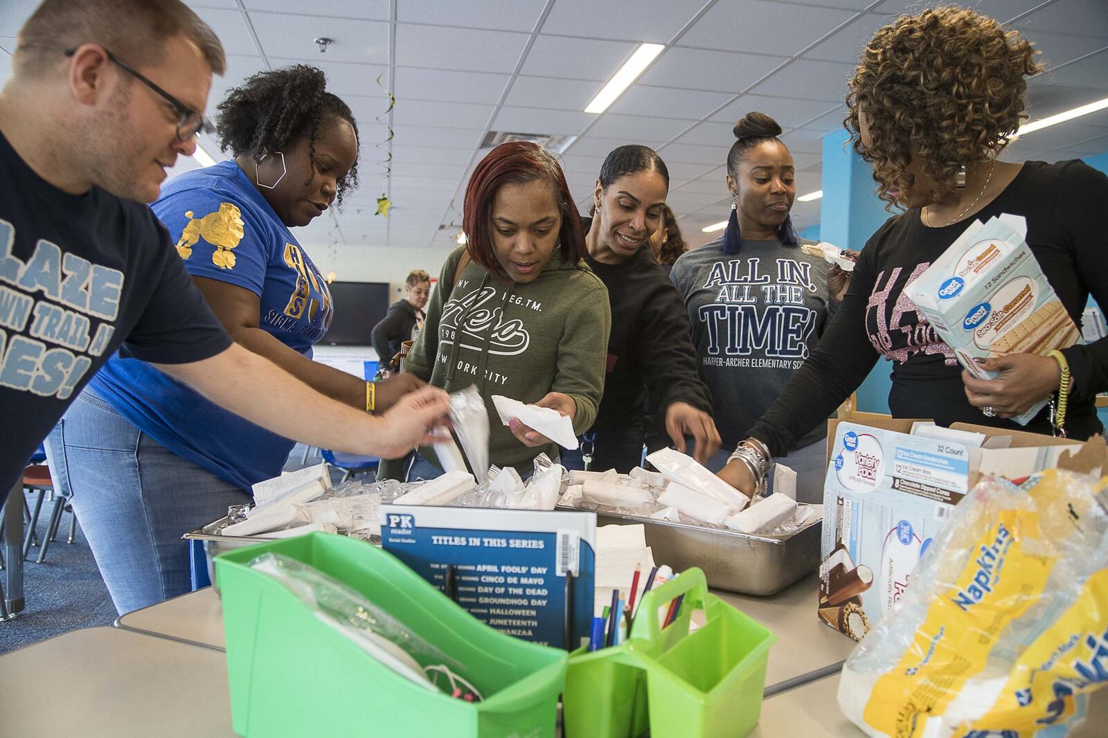 Harper-Archer Elementary School faculty and staff reach for ice cream bars before the start of a meeting with the principal in the school’s media center on Friday, March, 13, 2020. That day, Atlanta Public Schools closed its facilities to students and staff to try to stop the spread of the coronavirus. ALYSSA POINTER/ALYSSA.POINTER@AJC.COM