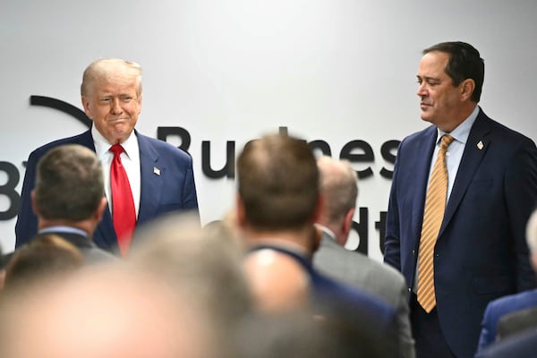 President Donald Trump arrives to speak at the Business Roundtable quarterly meeting in Washington, Tuesday, March 11, 2025, as Business Roundtable Chair and Cisco Chairman and CEO Chuck Robbins watches. (Pool via AP)