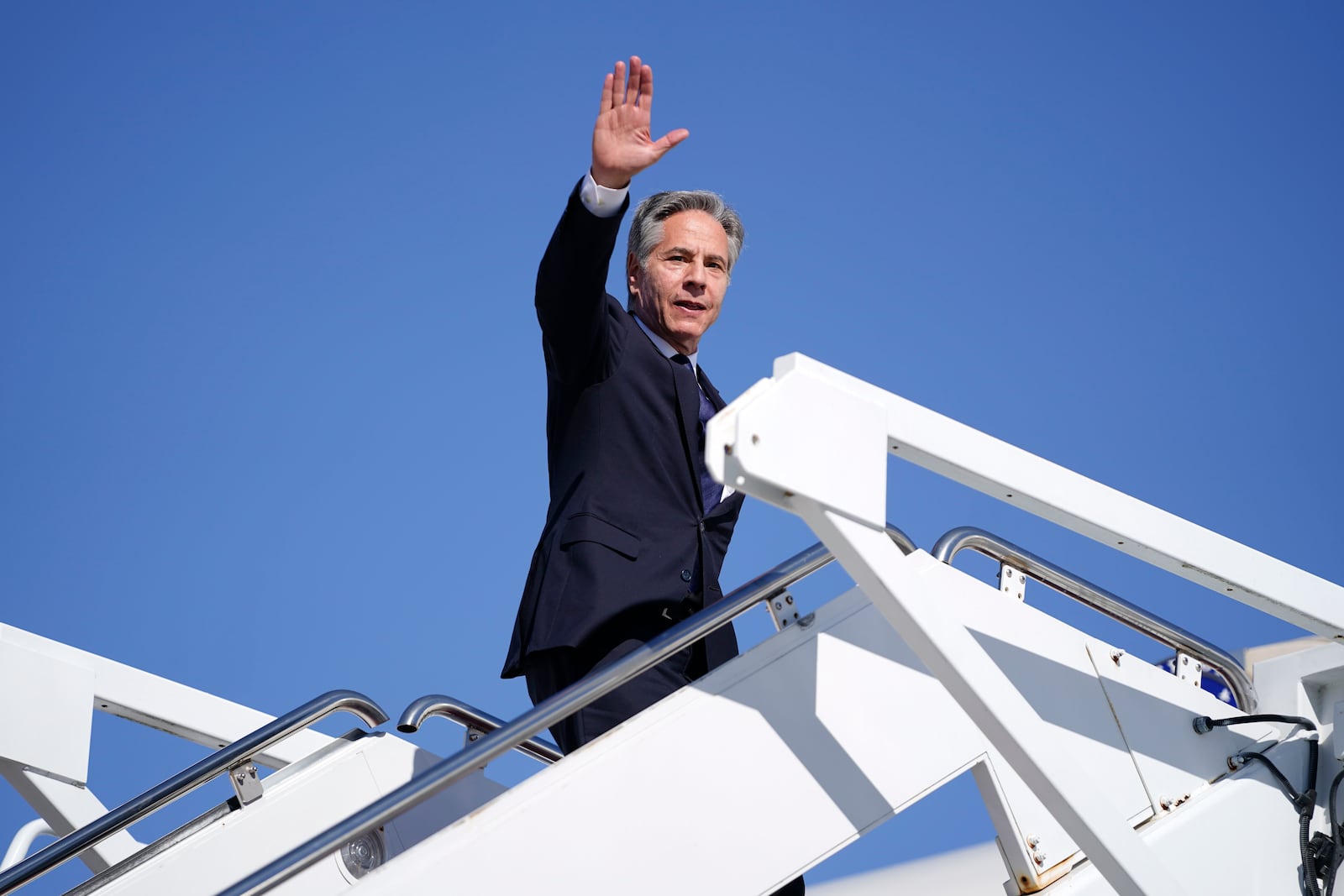 Secretary of State Antony Blinken waves as he boards a plane en route to the Middle East as he departs Joint Base Andrews, Md., Monday, Oct. 21, 2024. (Nathan Howard/Pool Photo via AP)