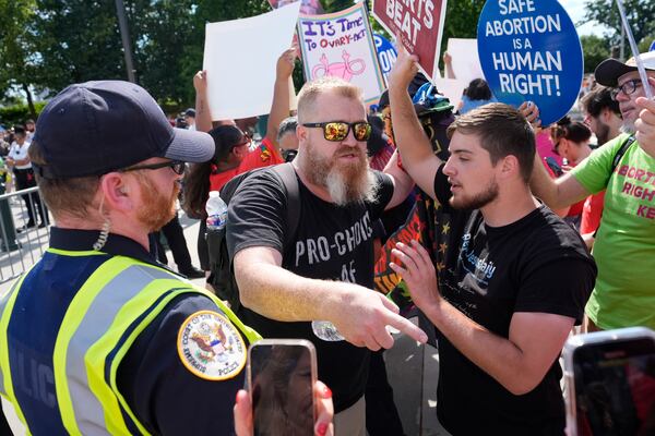 A Supreme Court police officer monitors the scene as abortion rights activists and Women's March leaders clash with anti-abortion counter-protesters during a national day of strike actions outside the Supreme Court, Monday, June 24, 2024, in Washington. (AP Photo/Alex Brandon)