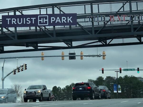 A temporary version of Truist Park signage has been placed on pedestrian bridges leading to the Braves’ stadium.