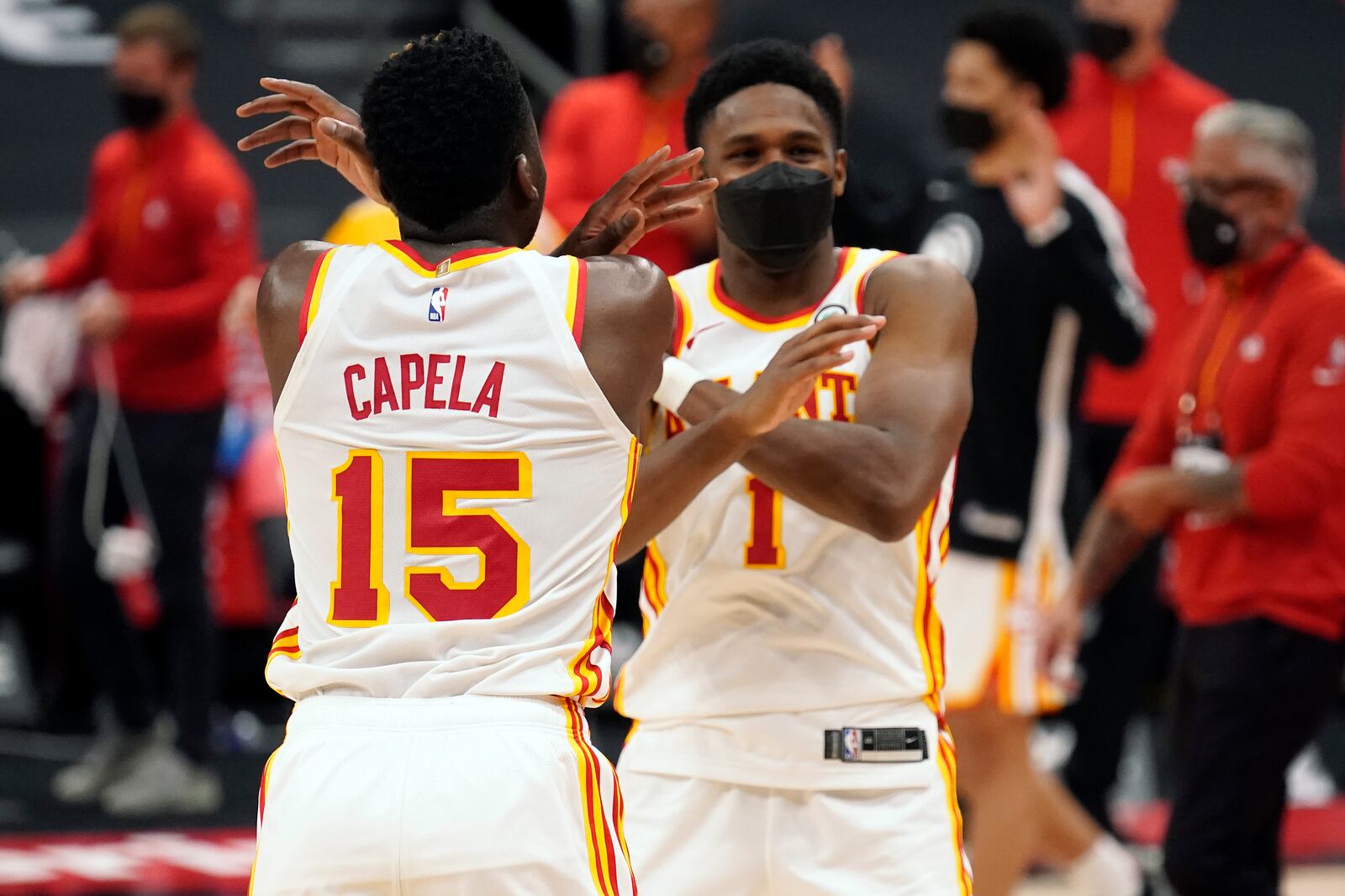 Atlanta Hawks center Clint Capela (15) and forward Nathan Knight (1) celebrate their win over the Toronto Raptors during an NBA basketball game Tuesday, April 13, 2021, in Tampa, Fla. (AP Photo/Chris O'Meara)