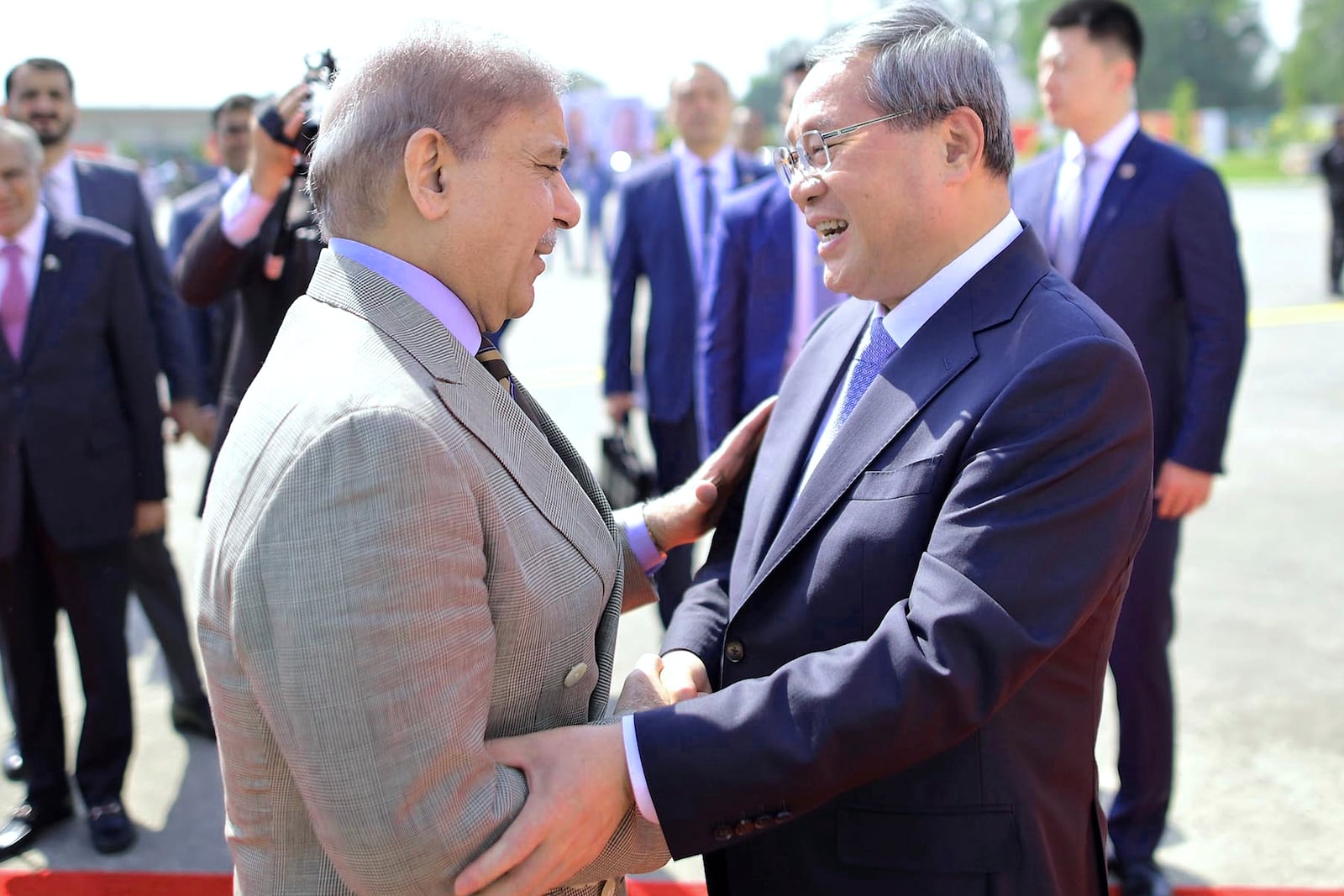 In this photo released by the Press Information Department, China's Premier Li Qiang, right, greets Pakistan's Prime Minister Shehbaz Sharif, upon his arrival at an airbase in Rawalpindi, Pakistan, Monday, Oct. 14, 2024. (Press Information Department via AP)