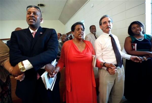 Meridian Mayor Percy Bland, left, holds hands with civil rights activist and widow of civil rights pioneer Medgar Evers, Myrlie Evers-Williams, and Dave Goodman, brother of slain civil rights worker Andrew Goodman during a ceremony at the Mt. Zion United Methodist Church in Philadelphia, Miss., Sunday, June 15, 2014. The commemorative service was for Goodman and two other civil rights workers killed in Neshoba County for their voter registration work among blacks in then segregationist Mississippi. (AP Photo/Rogelio V. Solis)