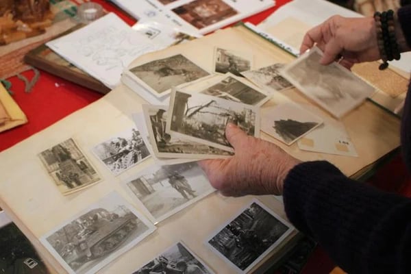 Going through dozens of photos Janet Byington tells the story of her father, Lt. Archibald Farrar, and his time fighting in World War II. (Photo Courtesy of Rachel Hartdegen)