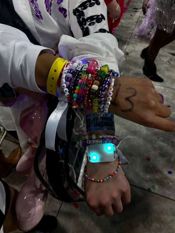 Amanda Owen and Enid McCarthy show off handmade multiple bracelets with popular song titles and sayings to trade with other fans at the sold-out Taylor Swift concert at Mercedes-Benz Stadium in Atlanta on Friday, April 23, 2023.  (Kelly Audette / Kelly.Audette@ajc.com)