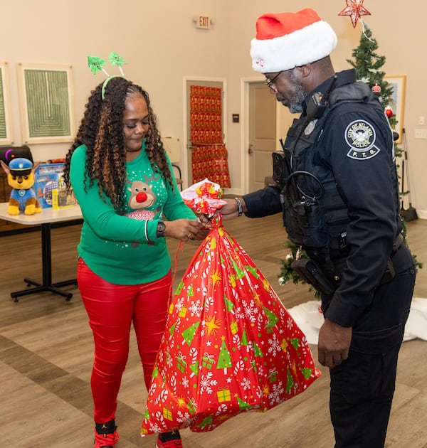 Event coordinator Shacole Pearman and Atlanta Police Officer Russel Stanio prepare gifts for kids in the Amani Place Apartment Homes community Center. 
PHIL SKINNER FOR THE ATLANTA JOURNAL-CONSTITUTION