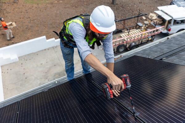 Joe McClain, an installer for Creative Solar USA, installs solar panels on a home in Ball Ground, Georgia on December 17, 2021. Solar advocates want the Public Service Commission to expand a popular residential and commercial solar program that filled up last year.