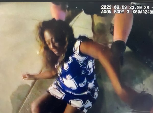 A police officer tries to pick Clayton County Commissioner Felicia Franklin from the pavement after finding her outside a sports bar.