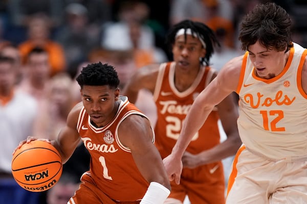 Texas guard Julian Larry (1) moves against Tennessee forward Cade Phillips (12) during the second half of an NCAA college basketball game in the quarterfinal round of the Southeastern Conference tournament, Friday, March 14, 2025, in Nashville, Tenn. (AP Photo/George Walker IV)