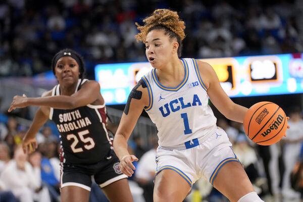 UCLA guard Kiki Rice (1) dribbles against South Carolina guard Raven Johnson (25) during the second half of an NCAA college basketball game, Sunday, Nov. 24, 2024, in Los Angeles. (AP Photo/Eric Thayer)