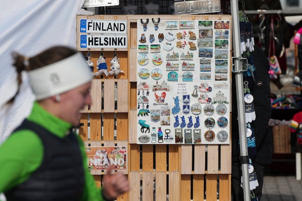 Woman pass by variety fridge magnets displayed at store on the Market Square in the center of Helsinki, Finland, Saturday, March 15, 2025. (AP Photo/Sergei Grits)