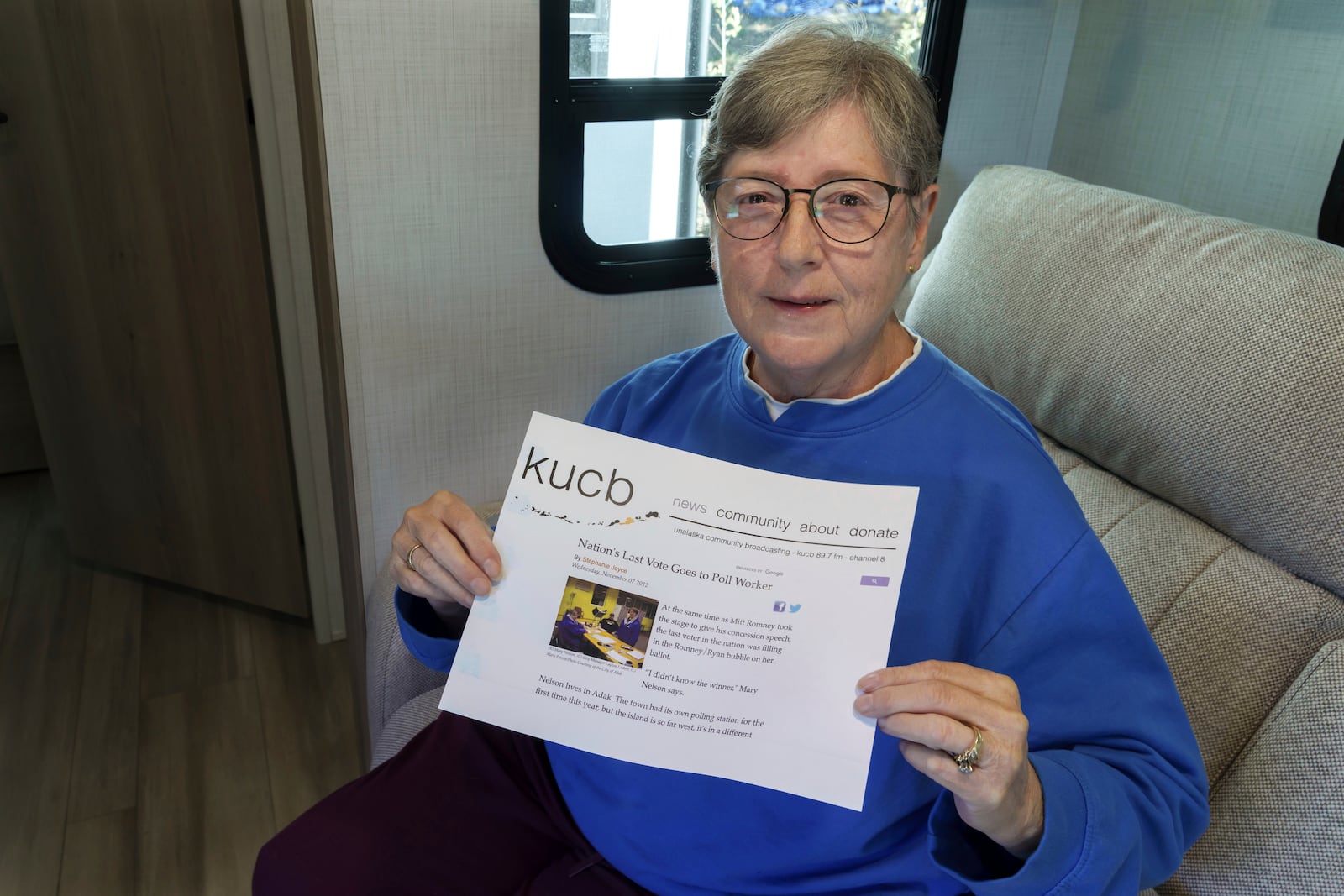 Mary Nelson, of Mead, Wash., poses for a photo at her home on Wednesday, Oct. 2, 2024. Nelson is holding a printout of a radio station website news story that says she is thought to be the last person in the U.S. to cast a vote in the 2012 presidential election when she voted for Mitt Romney just before the polls closed in the remote village of Adak, Alaska. (AP Photo/Ted S. Warren)