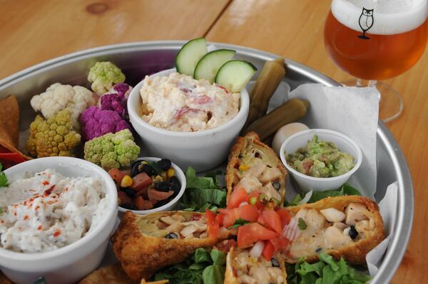 Vic’s appetizer sampler, with house pimento cheese, pickled vegetables, smoked chicken egg rolls and smoked catfish dip, served here with Wild Heaven White Blackbird. (Beckystein.com)