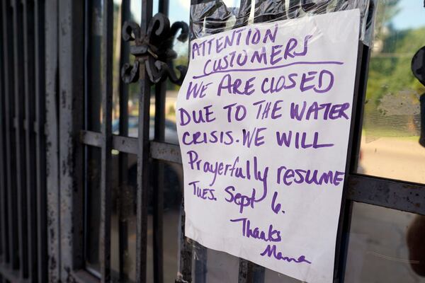 FILE - A sign taped to the door of the closed Mama's Eats and Sweets restaurant is one of the casualties of the water crisis Friday Sep. 2, 2022, in Jackson, Miss. (AP Photo/Steve Helber, File)