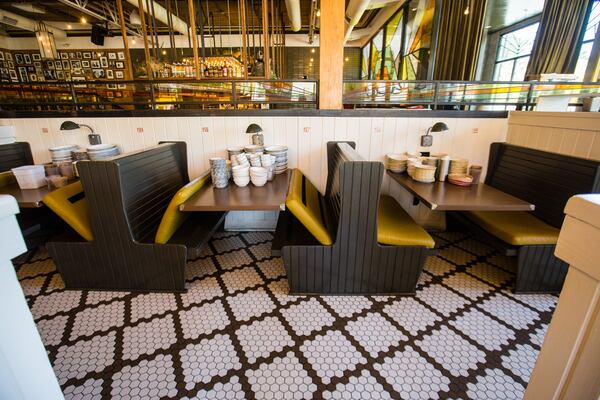 Plates and glassware were stored on empty tables at Superica on Roswell Road on March 25 to make room in the kitchen for disposable, takeout containers. The next day the restaurant closed completely, also ending takeout orders. (Jenni Girtman for The Atlanta Journal Constitution)