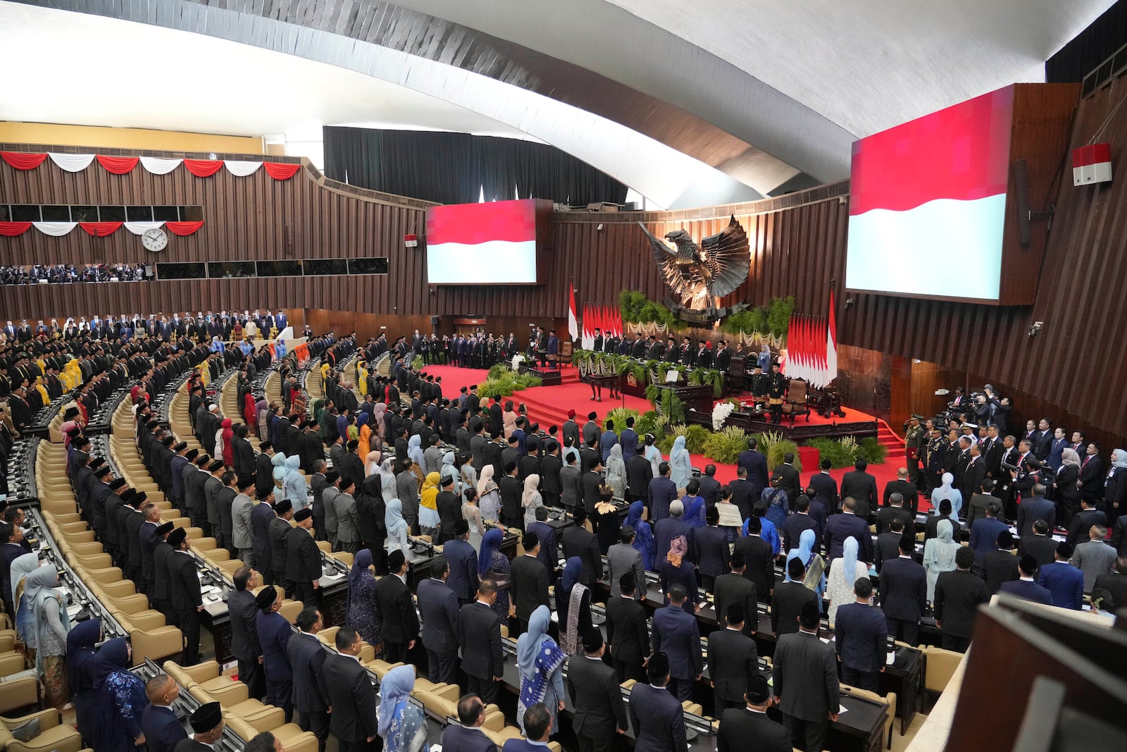 Members of the People's Consultative Assembly stand as the national anthem is played during the swearing-in ceremony of Indonesia's new President Prabowo Subianto at the parliament building in Jakarta, Indonesia Sunday, Oct. 20, 2024. (AP Photo/Tatan Syuflana)