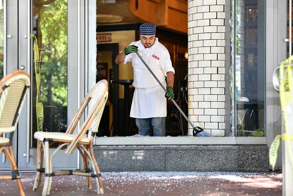 An employee cleans up after a night of riots and looting in Buckhead area at Bistro Niko restaurant on Peachtree Road in Buckhead. AJC Photo: Hyosub Shin