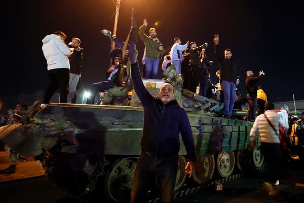 Syrians celebrate the arrival of opposition fighters in Damascus, Syria, Sunday, Dec. 8, 2024. (AP Photo/Omar Sanadiki)