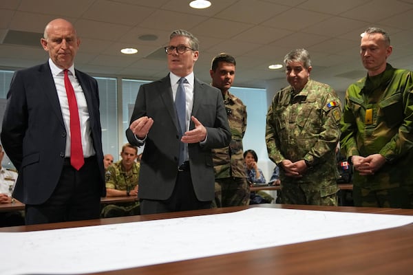 Britain's Prime Minister Keir Starmer and John Healey, Secretary of State for Defence, center left, look at a Ukraine map as they visit a military base to meet planners mapping out next steps in the Coalition of the Willing in Northwood, London, Thursday, March 20, 2025.(AP Photo/Alastair Grant, Pool)