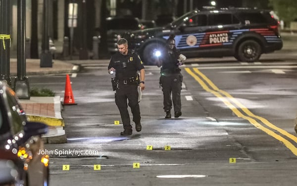 Investigators placed multiple yellow evidence tags in the street to mark spent shall casings.