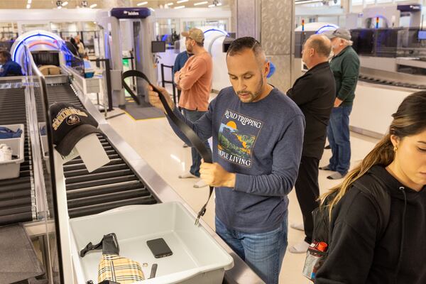 Travelers pass through a newly reopened lane during a security screening in the domestic terminal at Hartsfield-Jackson in Atlanta on Thursday, December 14, 2023. (Arvin Temkar / arvin.temkar@ajc.com)