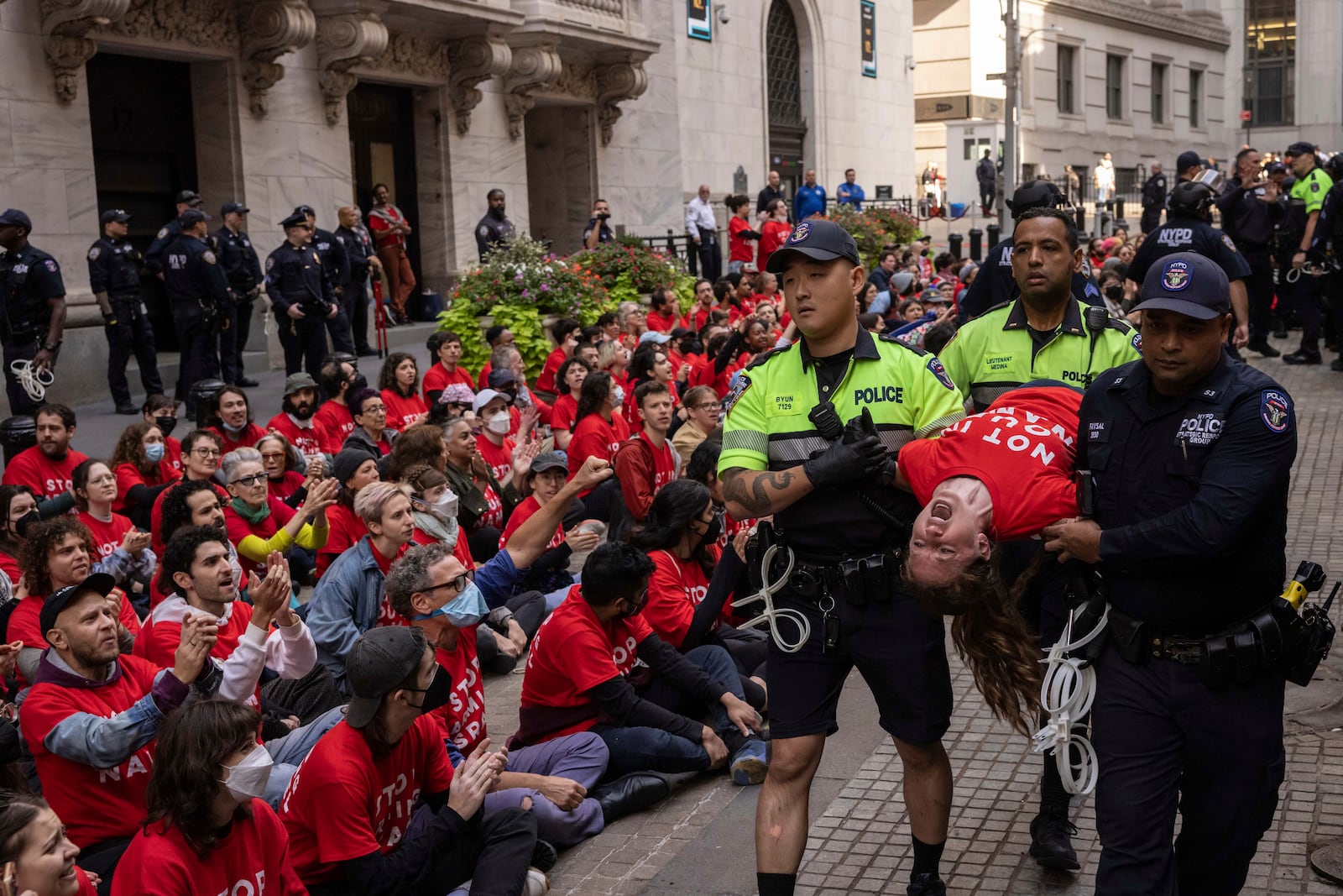 Police officers detain a demonstrator protesting Israel's war against Hamas as they occupy an area outside the New York Stock Exchange, Monday, Oct. 14, 2024, in New York. (AP Photo/Yuki Iwamura)