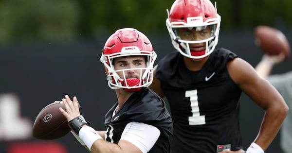 Georgia quarterback Jake Fromm (11) throws a pass as freshman quarterback Justin Fields (1) looks on during their practice Friday, Aug. 3, 2018 in Athens.