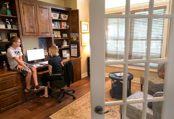 Brittany Podolak is a Human Resources Executive with Dell and telecommutes from her home office in Cedar Park, TX most days. She has dedicated office space with double doors that can be shuttered to signify when she's working or not for her family to see. Her son Jack, 11, checks in during a break in work to discuss his day at camp. Several of Austin's major employers are embracing the work-from-home trend, in part because it saves them money, but also to attract Millennials. Among the leaders in telecommuting policies is Dell, which has an ambitious plan to have 50 percent of its workforce working from home by 2020. This also means changes in the way their office spaces look as fewer employees means fewer cubicle farms. 
RALPH BARRERA/AMERICAN-STATESMAN