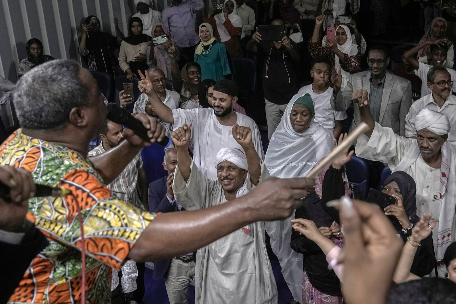 Sudanese Camirata troupe founder Dafallah el-Hag performs as Sudanese and foreign audience react during a show at the Russian culture center in Cairo, Egypt, Sunday, Sept. 15, 2024. (AP Photo/Amr Nabil)