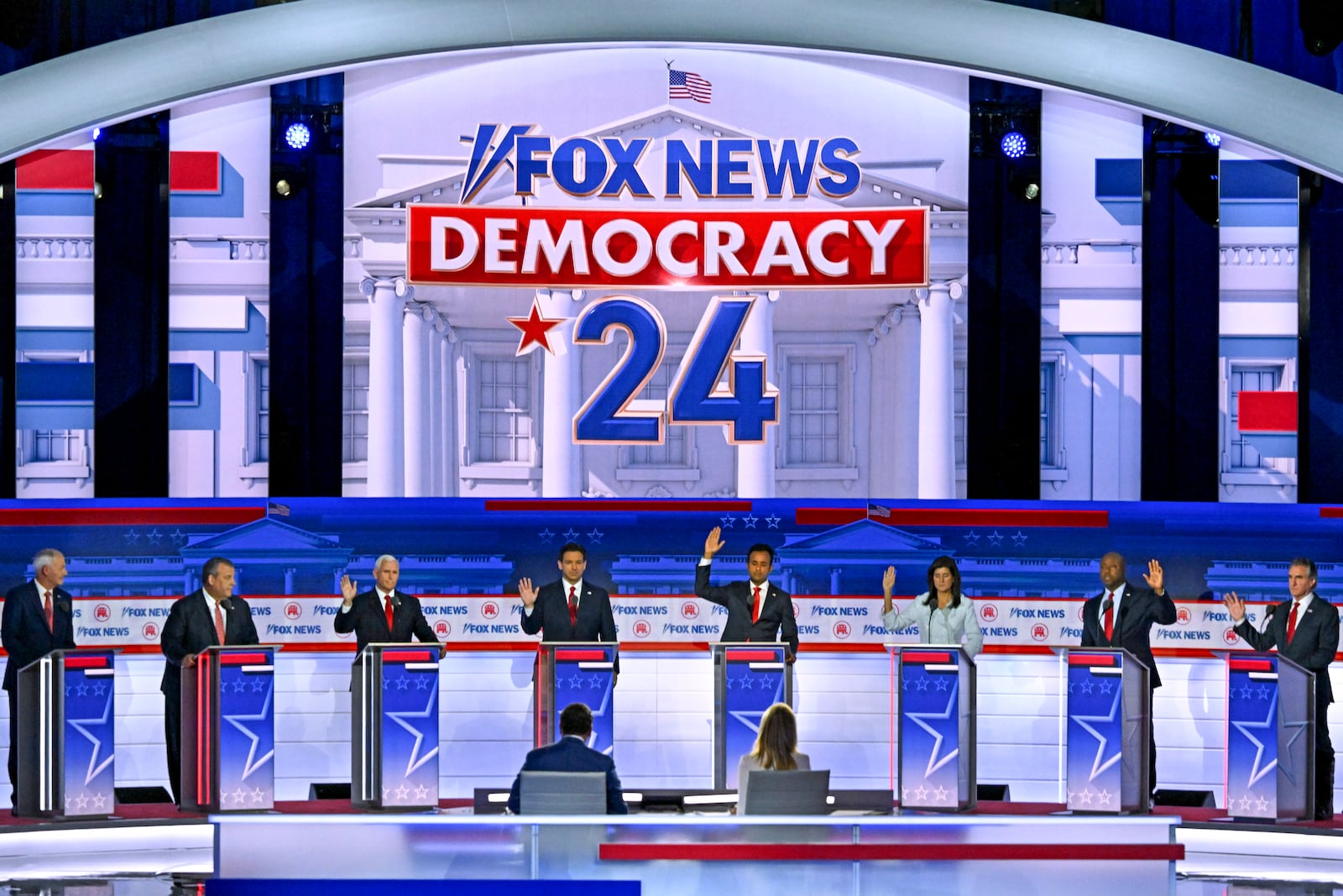 Candidates raise hands when asked if they would pardon former President Donald Trump, during the first Republican presidential primary debate, at the Fiserv Forum in Milwaukee on Wednesday, Aug. 23, 2023. From left: former Arkansas Gov. Asa Hutchinson, former New Jersey Gov. Chris Christie, former Vice President Mike Pence, Gov. Ron DeSantis of Florida, the entrepreneur Vivek Ramaswamy, former South Carolina Gov. Nikki Haley, Sen. Tim Scott (R-S.C) and Gov. Doug Burgum of North Dakota. (Kenny Holston/The New York Times).