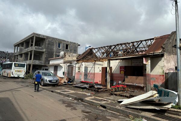 A man walk in a damaged street in Mamoudzou, in the French Indian Ocean territory of Mayotte, Monday, Dec.16, 2024 and France uses ships and military aircraft to rush rescue workers and supplies after the island group was battered by its worst cyclone in nearly a century. (AP Photo/Rainat Aliloiffa)