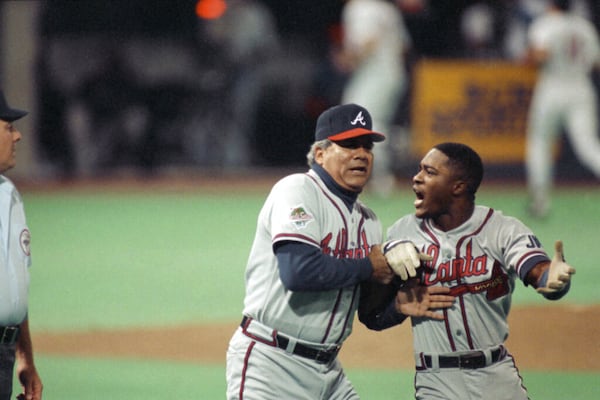 Atlanta Braves first base coach Pat Corrales holds back an angry Ronnie Gant, right, after he was called out on a controversial play during the third inning of Game 2 at the World Series in Minneapolis, Oct. 21, 1991. Gant felt that Minnesota Twins first baseman Kent Hrbek had knocked him off the base. Gant was rule out and the Twins went on to beat the Braves 3-2. (AP Photo/Bill Waugh)