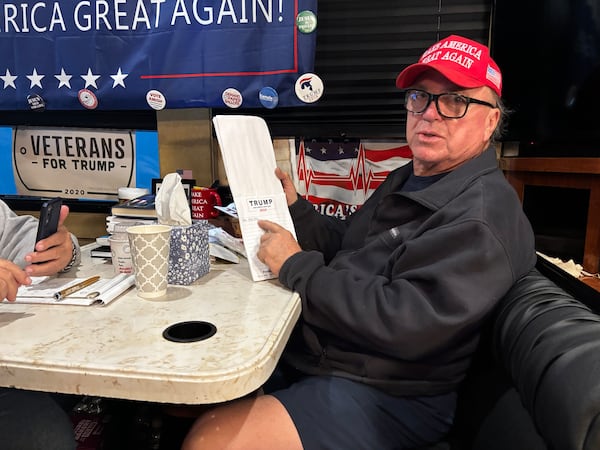 Danny Hamilton shows a "finger poll" tally as he sits in one of seven buses packed with Trump supporters that he led from Atlanta to an RV park in suburban Maryland. AJC/ Greg Bluestein 