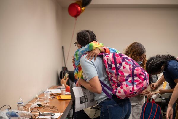 Immigrants and asylum seekers embrace each other and exchange contact information before departing from the care of Casa Alterna at Atlanta's Hartsfield-Jackson International Airport, Thursday, Aug. 19, 2021. Bonds were formed as the immigrants and asylum seekers spent time at Stewart Detention Center waiting to be granted access to live in the Untied States. (Alyssa Pointer/Atlanta Journal Constitution)