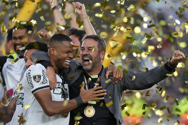 Coach Artur Jorge of Brazil's Botafogo, right, celebrates with his players after winning the Copa Libertadores final soccer match against Brazil's Atletico Mineiro at Monumental stadium in Buenos Aires, Argentina, Saturday, Nov. 30, 2024. (AP Photo/Gustavo Garello)