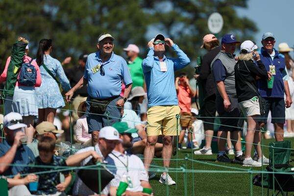 A patron uses eclipse glasses to view the solar eclipse on the 18th green during the practice round of the 2024 Masters Tournament at Augusta National Golf Club, Monday, April 8, 2024, in Augusta, Ga. (Jason Getz / jason.getz@ajc.com)