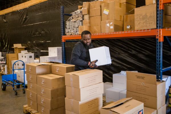 Avant Partir warehouse manager Eugene Holland works to package pallets of wine for distribution on Wednesday, March 26, 2020.   Eugene usually has another person working with him in the warehouse.  Avant Partir is a high-end wine distributor in Duluth, and has modified purchases and is moving much less product to restaurants and retailers in recent weeks due to the coronavirus.  The business is working to keep all employees on the payroll but is cutting back hours and taking turns in the warehouse.  (Jenni Girtman for the Atlanta Journal Constitution)