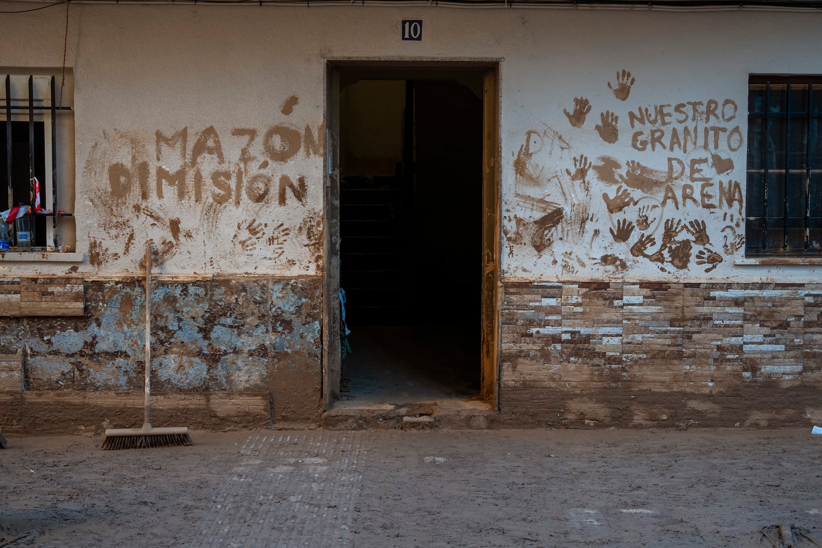 A house affected by flooding is photographed in Massanassa, Valencia, Spain, Friday, Nov. 8, 2024. The graffiti in Spanish means 'Mazon dimisión' in reference to the president of the Valencia community Carlos Mazon. (AP Photo/Emilio Morenatti)