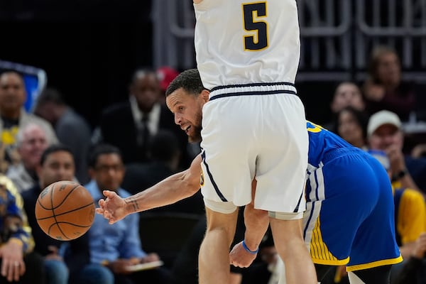 Golden State Warriors guard Stephen Curry, right, passes while defended by Denver Nuggets forward Hunter Tyson (5) during the second half of an NBA basketball game Monday, March 17, 2025, in San Francisco. (AP Photo/Godofredo A. Vásquez)