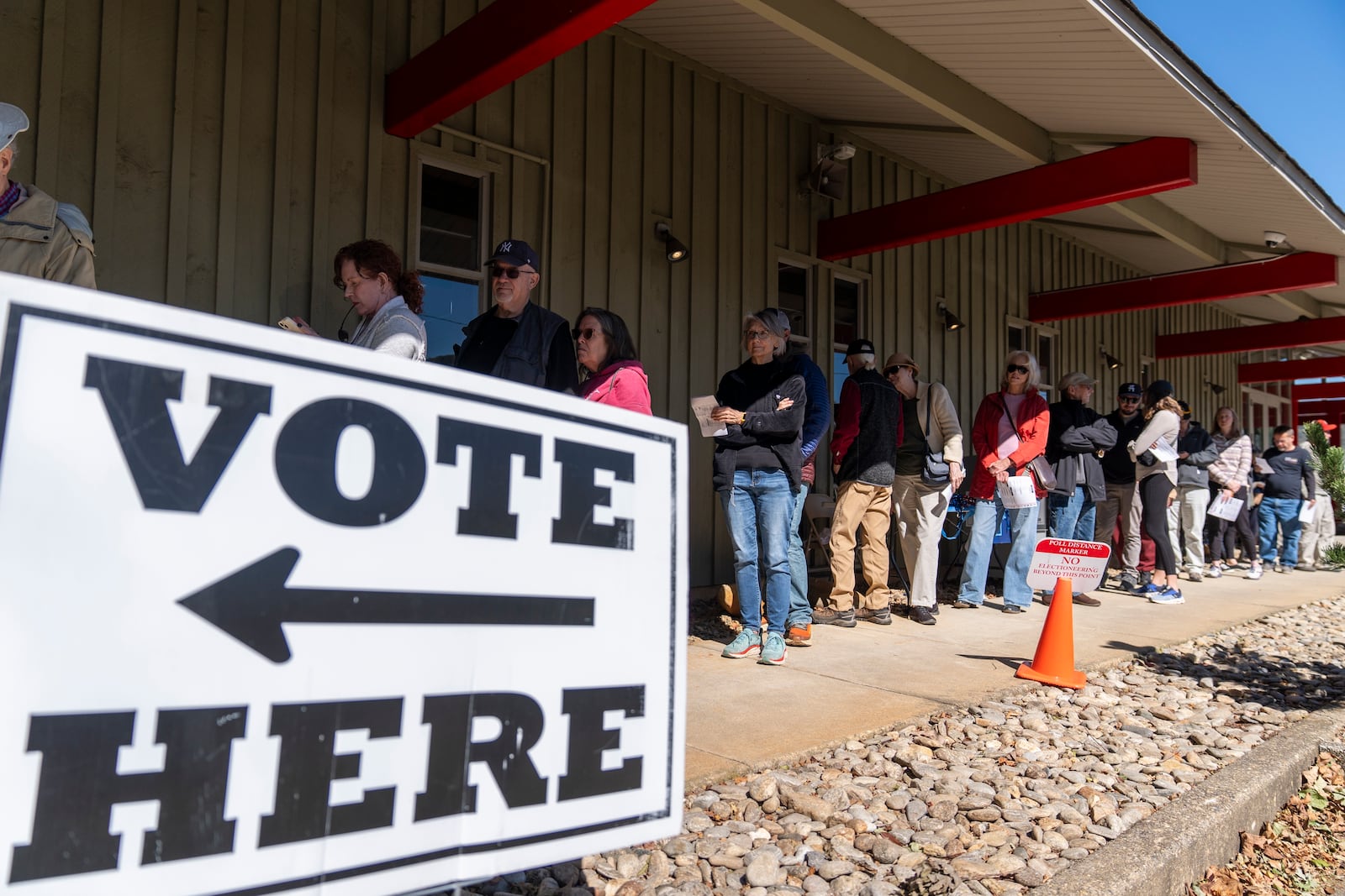 People stand in line at a polling place on the first day of early in-person voting in Black Mountain, N.C., Thursday, Oct. 17, 2024. (AP Photo/Stephanie Scarbrough)