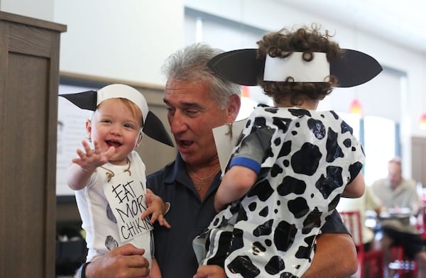 Alex Rodriguez, store operator at Chick-fil-A on Hammond Drive in Atlanta, greets Issac Timberline, 1, and Nolan Timberline, 3, on Cow Appreciation Day 2016.