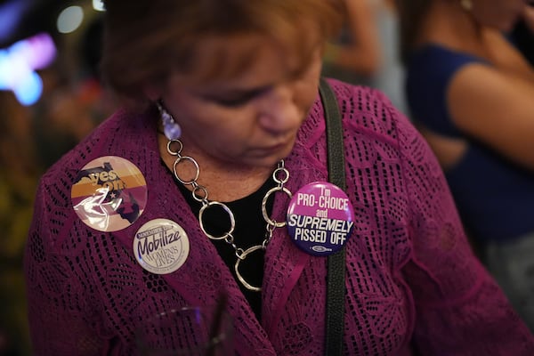 Denise Yettow wears a pair of buttons she saved from the 1989 Mobilize for Women's Lives Rally, as she gathers with supporters of Florida's Amendment 4, which would enshrine abortion rights in the state, for a watch party for the Yes On 4 campaign, on Election Day, Tuesday, Nov. 5, 2024, in St. Petersburg, Fla. (AP Photo/Rebecca Blackwell)