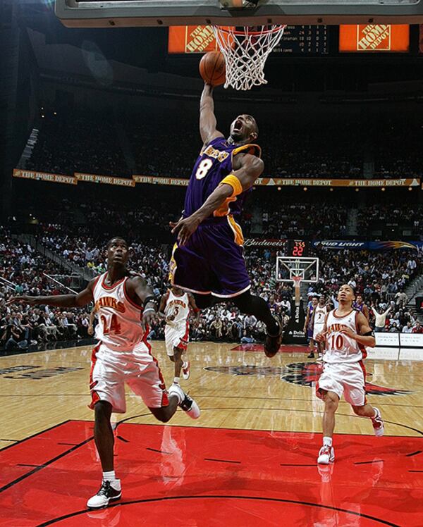 Kobe Bryant dunks in front of Hawks Marvin Williams (left) and Tyronn Lue during the second half of Atlanta's home opener Nov. 8, 2005, at Philips Arena.