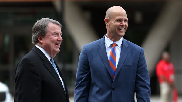 National Football Foundation President and CEO Steve Hatchell (left) and College Football Hall of Famer Danny Wuerffel react during the sign unveiling ceremony for the Chick-fil-A College Football Hall of Fame on Thursday, May 24, 2018, in Atlanta. (Jason Getz/AJC)