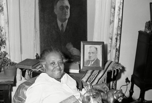 Elizabeth "Lizzie" McDuffie, who was a maid to Franklin Delano Roosevelt, when he was president, is shown in her Atlanta home with some of the souvenirs he gave her. They include a bible, a walking cane, a gallon jug with his picture framed by a horseshoe, one of his old hats, a book "The Roosevelt Omnibus, " a bronze lion, an ash tray and several pictures. The painting in the background has never been shown before publicly, according to McDuffie, and this is the first time she and her mementos have been photographed together.